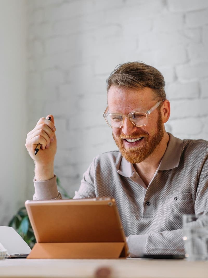 Coach smiling while reviewing a client session on a tablet