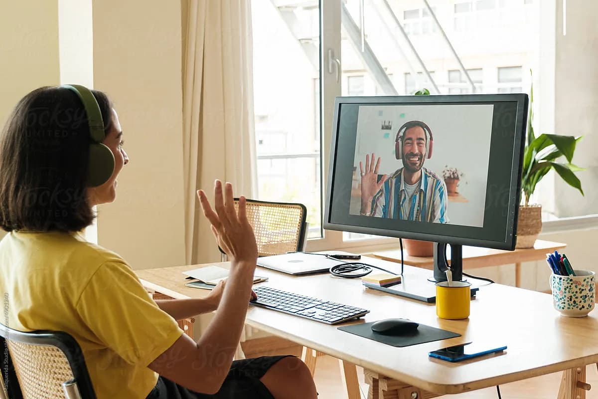 A coach and client meeting over a video call from their home offices
